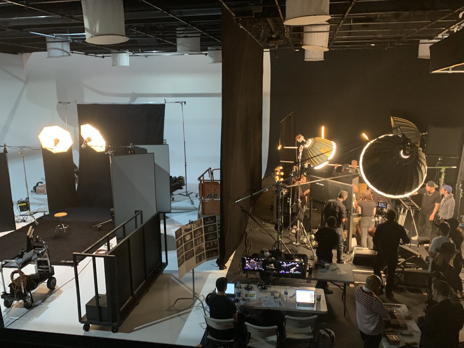 Wide shot of the Lion King Collection soundstage: a lit white cyclorama on the left, a ring-lit setup shooting on the right, and video village between them.